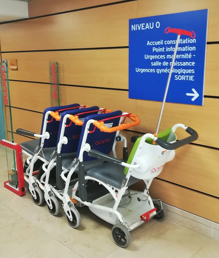 Row of transport wheelchairs in a hospital lobby
